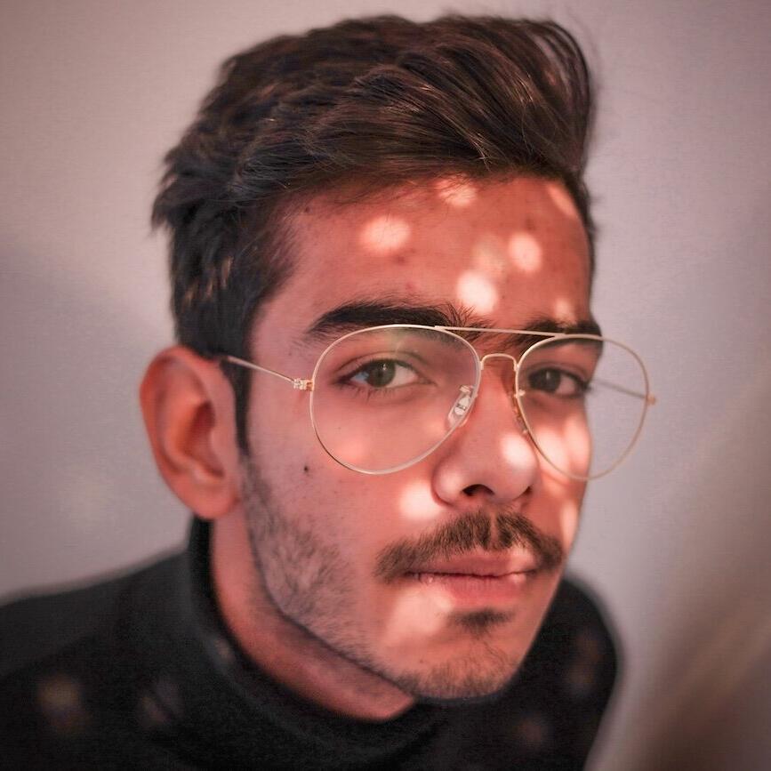 Mann im schwarzem Rundhalshemd mit silbergerahmter Brille © KULJEET PUNIA / Unsplash