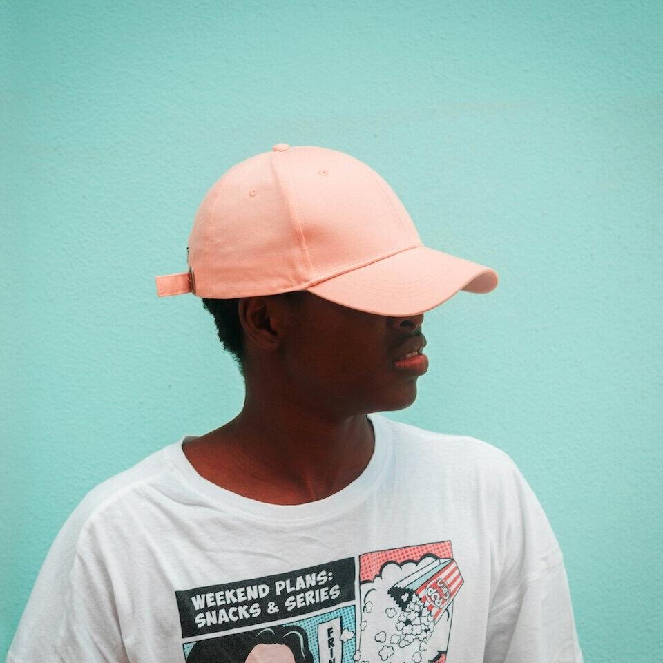 Mann mit weißen Rundhals-T-Shirt und pinker Cap